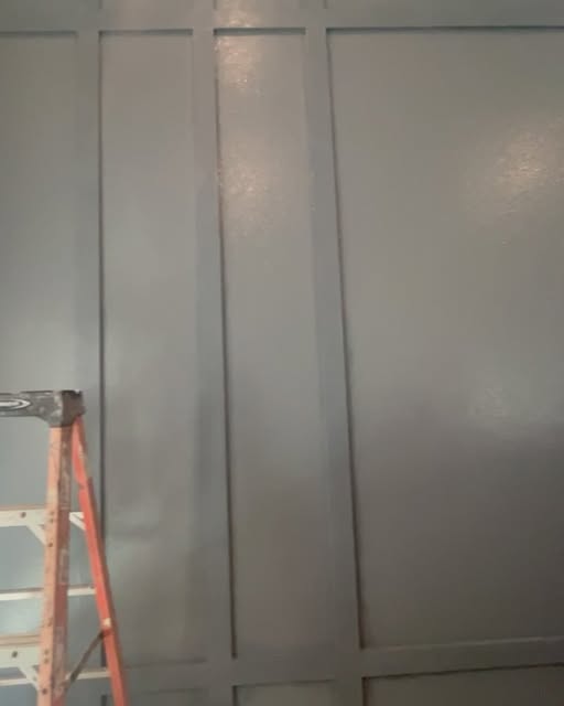 Freshly painted board-and-batten accent wall with ladder on site